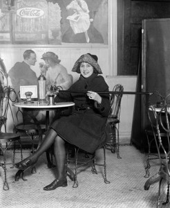 A fashionable young woman pours alcohol into a cup from a cane, February 1922