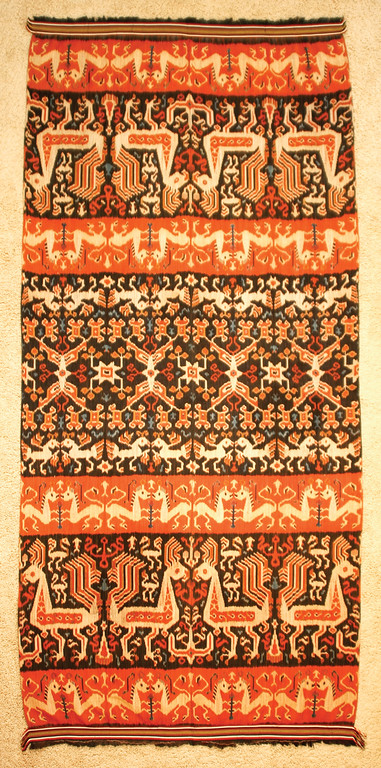 Dancing Threads Dancing Threads TAPIS Origin: Lampung, South Sumatra, Indonesia These intricate, elaborate skirts are hand dyed and hand woven by women to wear during important ceremonies. First woven and sewn into a large rectangle, the sides were then joined to create a tube for the woman to step into and wear as a sarong. Due to Lampung's position along major maritime routes and their own production of desirable trade goods, such as pepper and gold, the women of Lampung had ready access to a variety of iconography from other cultures and a wide range of trade materials. This wealth is on display here with the imaginative use of silk, cotton, mica and gold. The skills necessary to create these tapis gradually diminished during the early part of the twentieth century and were extinguished completely during World War II. Dancing Threads Dancing Threads HINGGI SUMBA ISLAND, INDONESIA Large, bold designs characterize the hinggi (men’s blankets) from the island of Sumba. The ikat patterns are dyed and woven by hand. Hinggi are usually made in pairs but then separated for reasons of utility, ritual or ceremony. Such pieces would be worn by a Sumbanese man - one around his hips, the other one around his shoulders. The finest hinggi were made as gifts to the nobility in order to be buried with them, with the unfortunate consequence that many of the most beautiful are gone. 